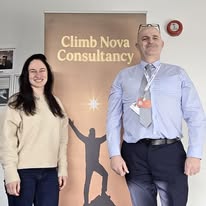 John Ryder with a Climb Nova Consultancy banner during support work