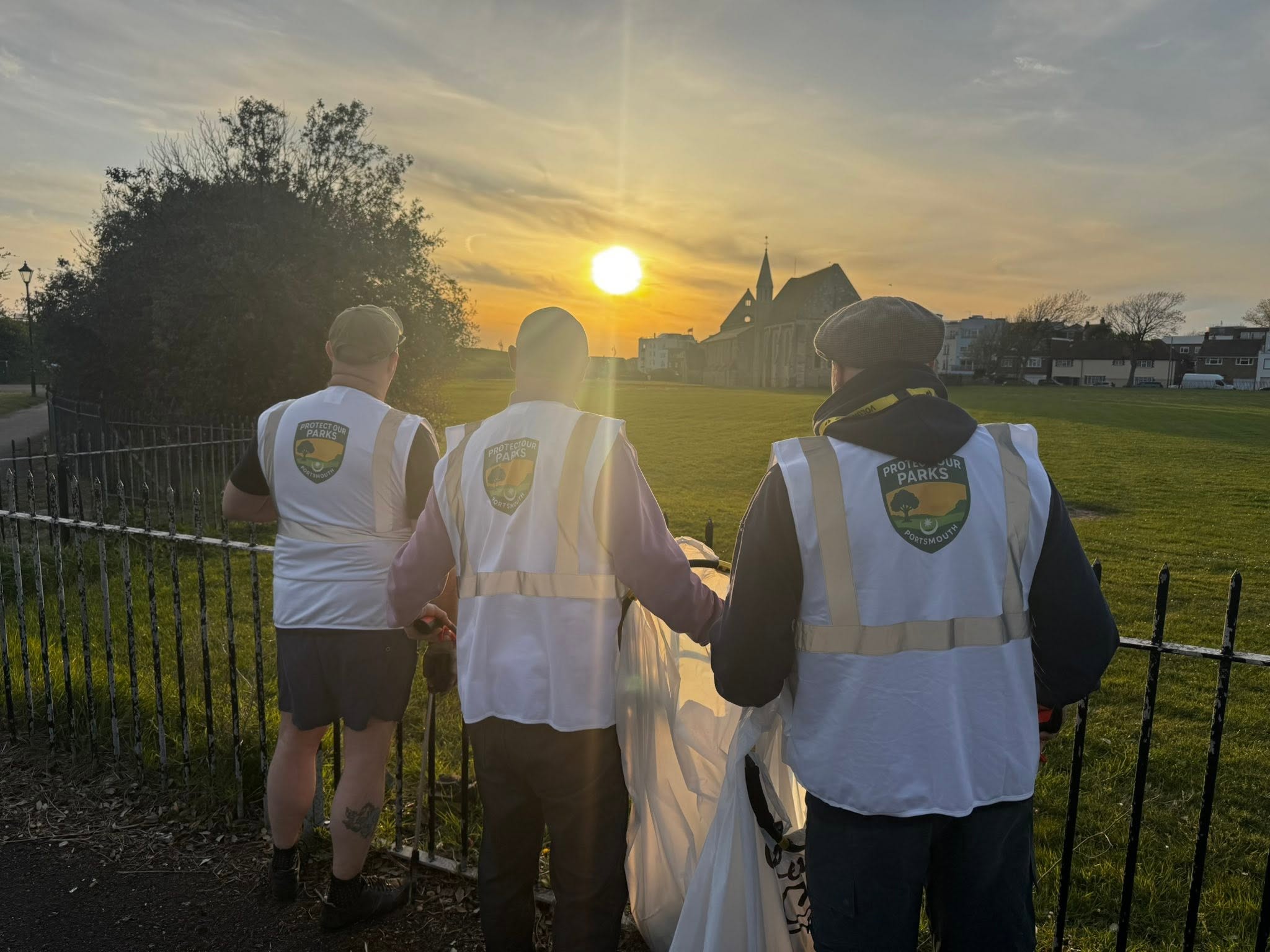 Protect Our Parks volunteers looking across a Portsmouth green space at sunset